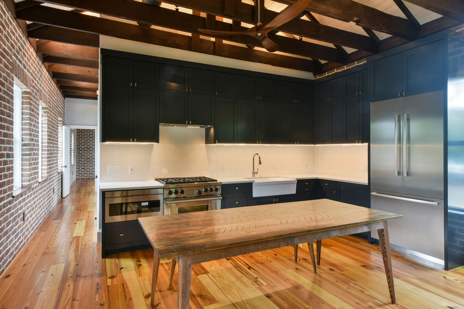 Modern coastal kitchen with navy blue cabinets and white tile backsplash designed by Swallowtail Architecture in Sullivan's Island, SC