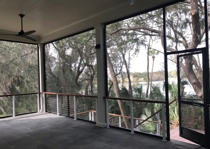Large screened porch with 11 foot ceilings in back of home