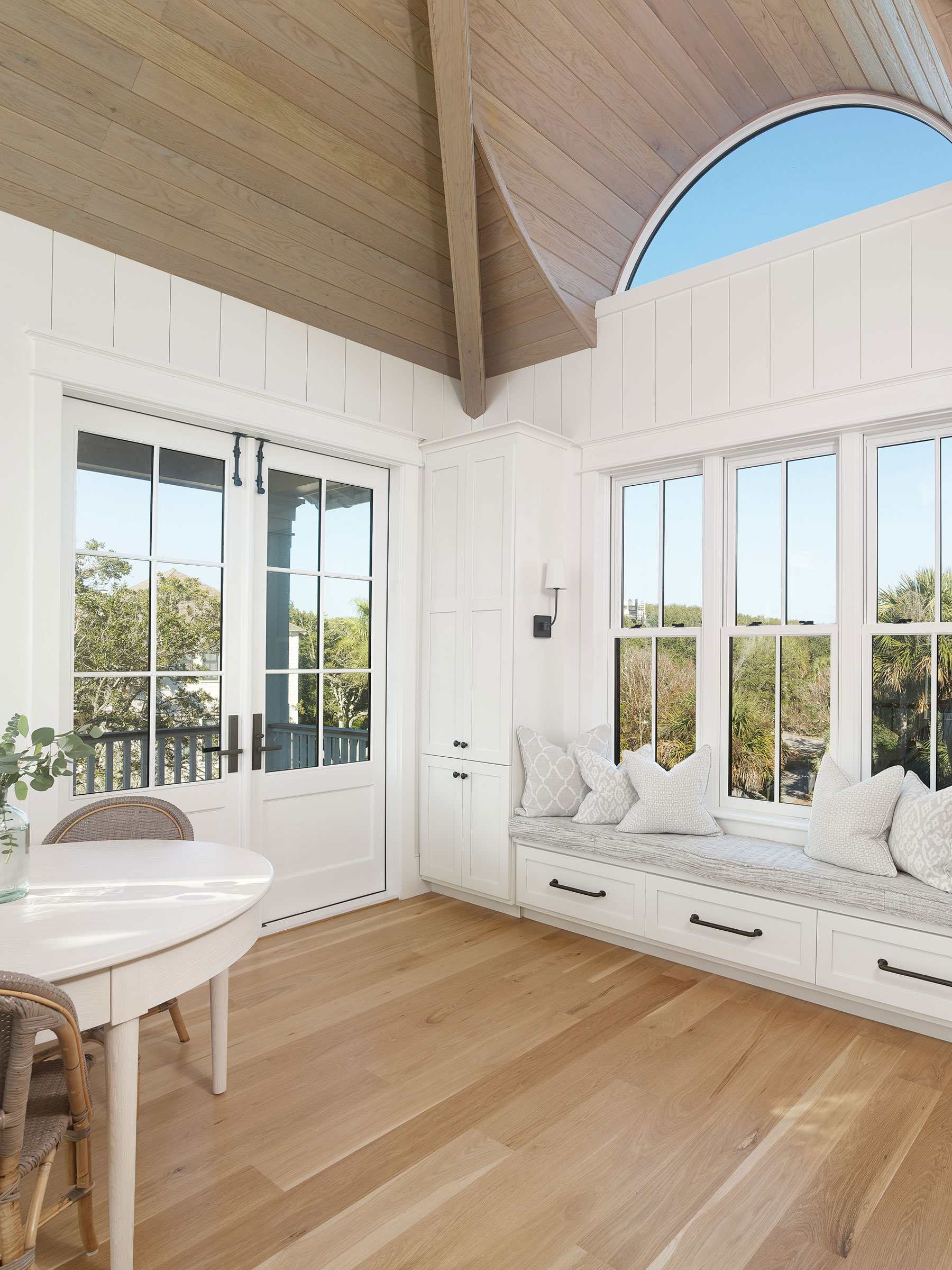 Window seat at the top of stairs in reverse plan beach house with barrel vault eyebrow window