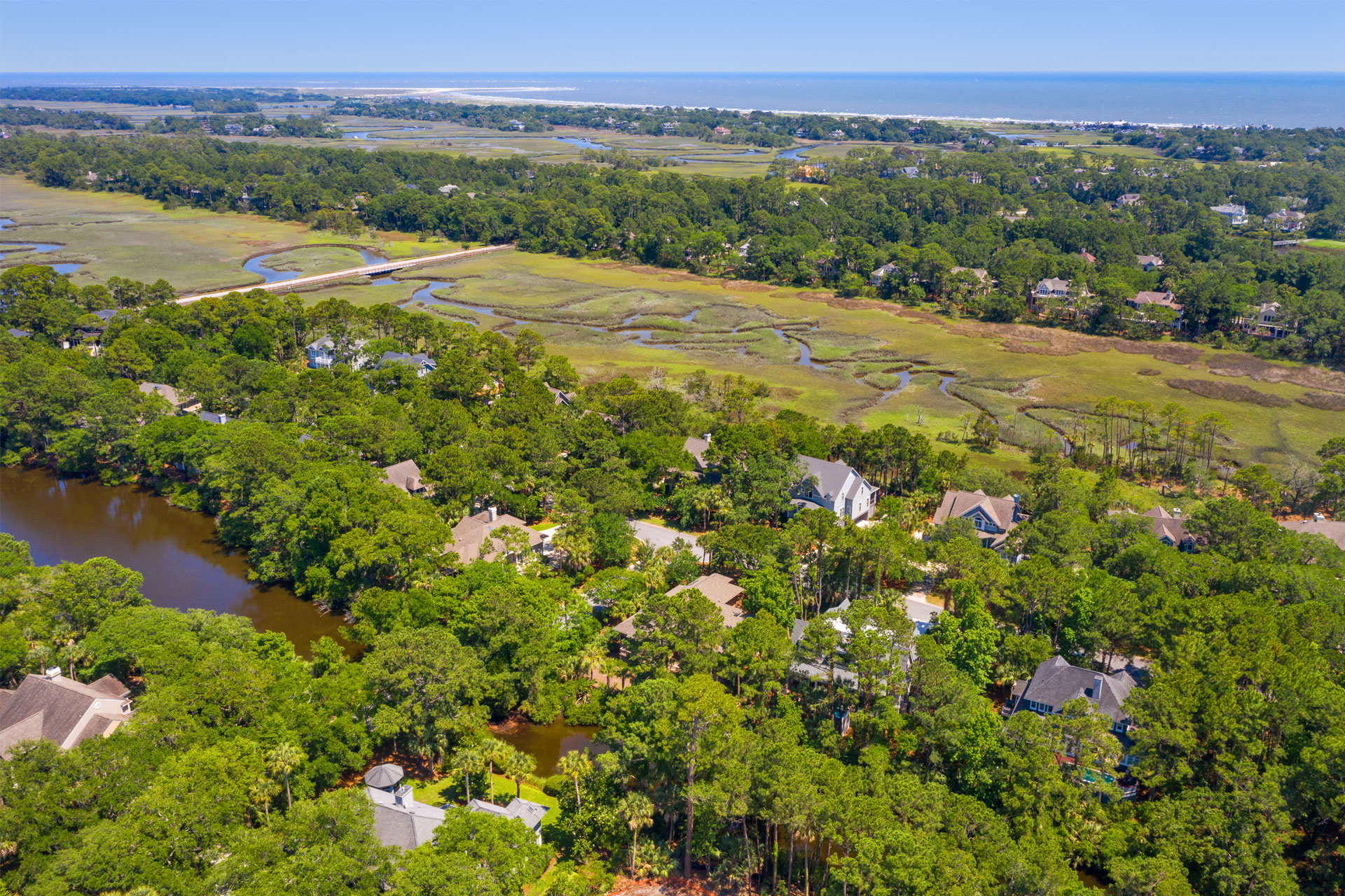 Aerial view of character lot with marsh and lagoon with house designed by Swallowtail Architecture