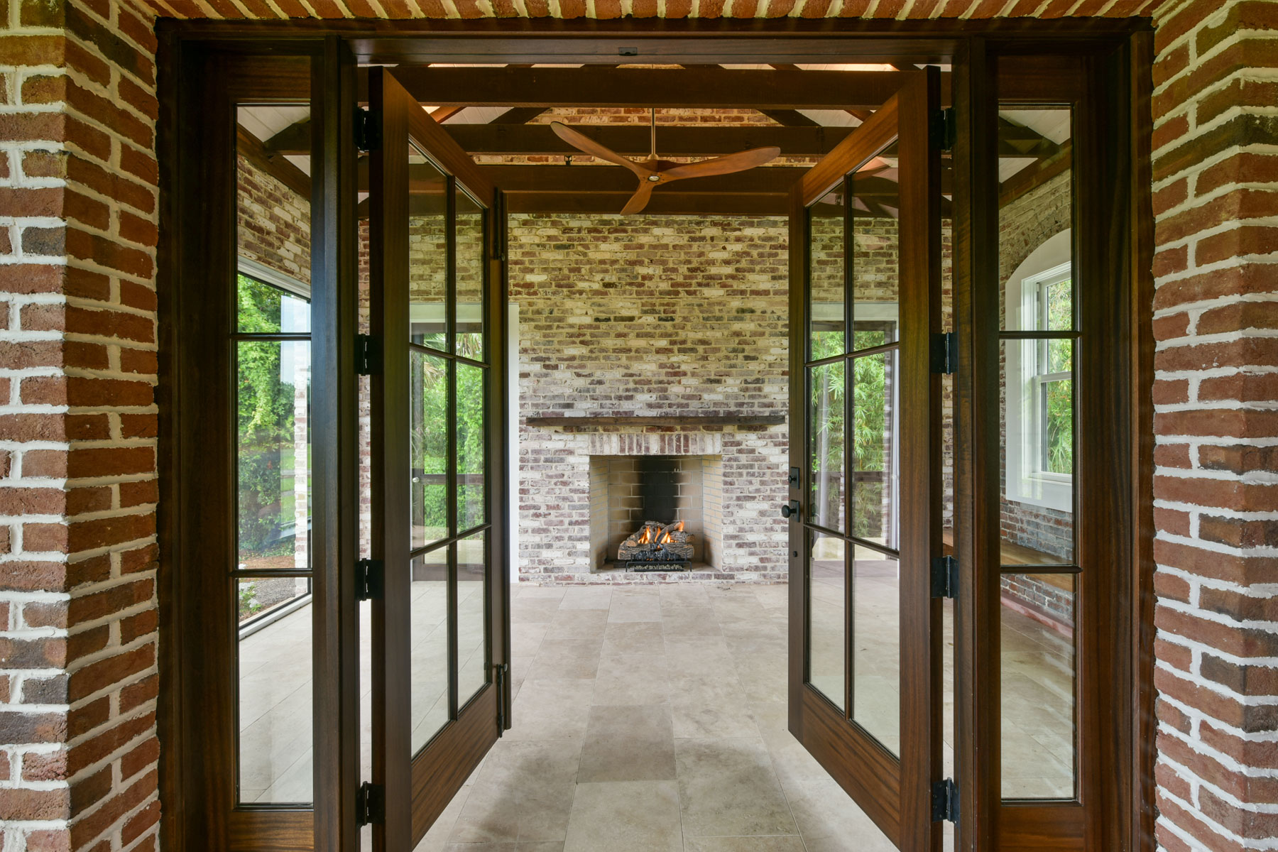 Wood stained French doors open to sunroom