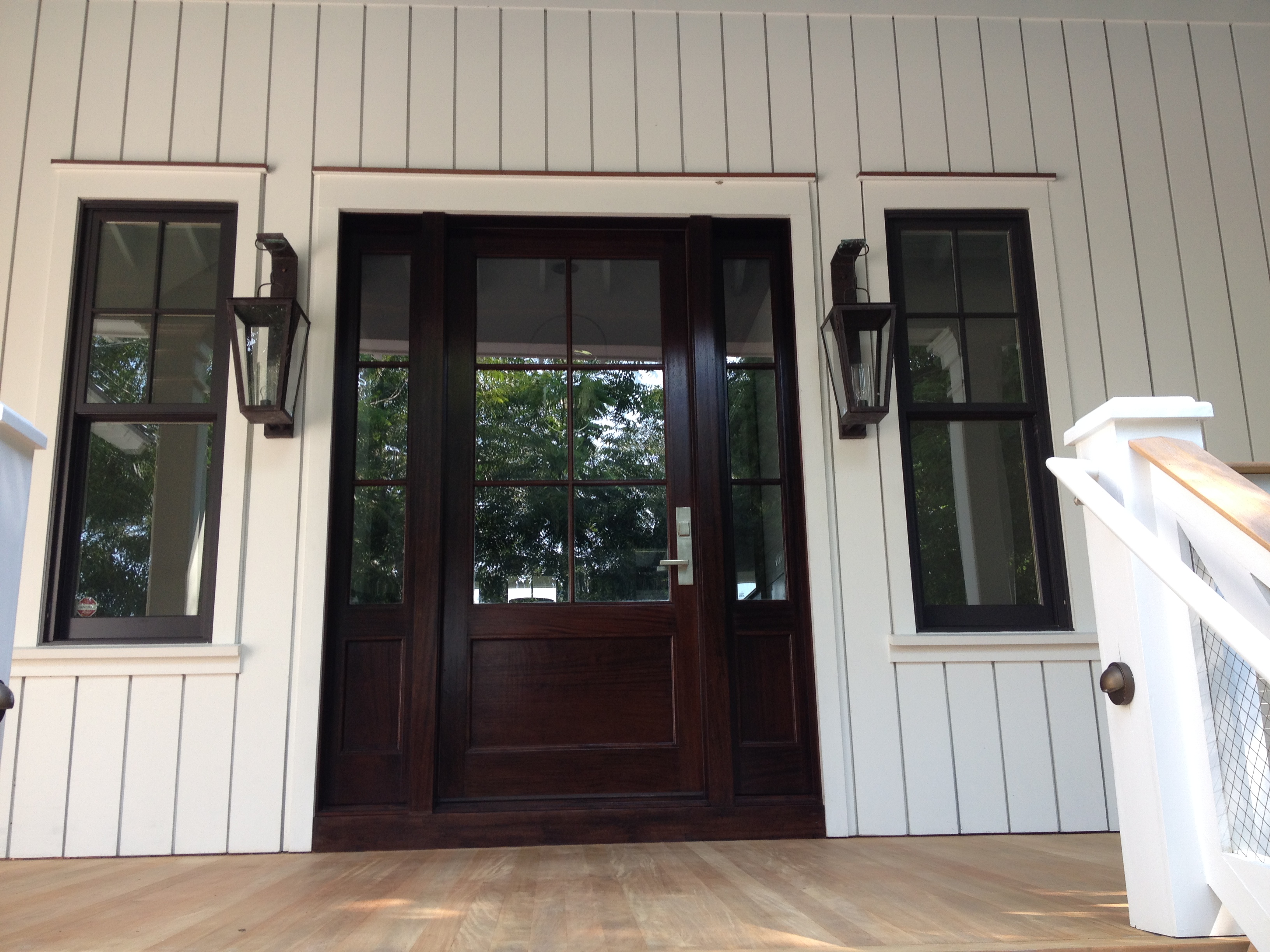 Dark wood stained front door flanking sidelights on coastal home