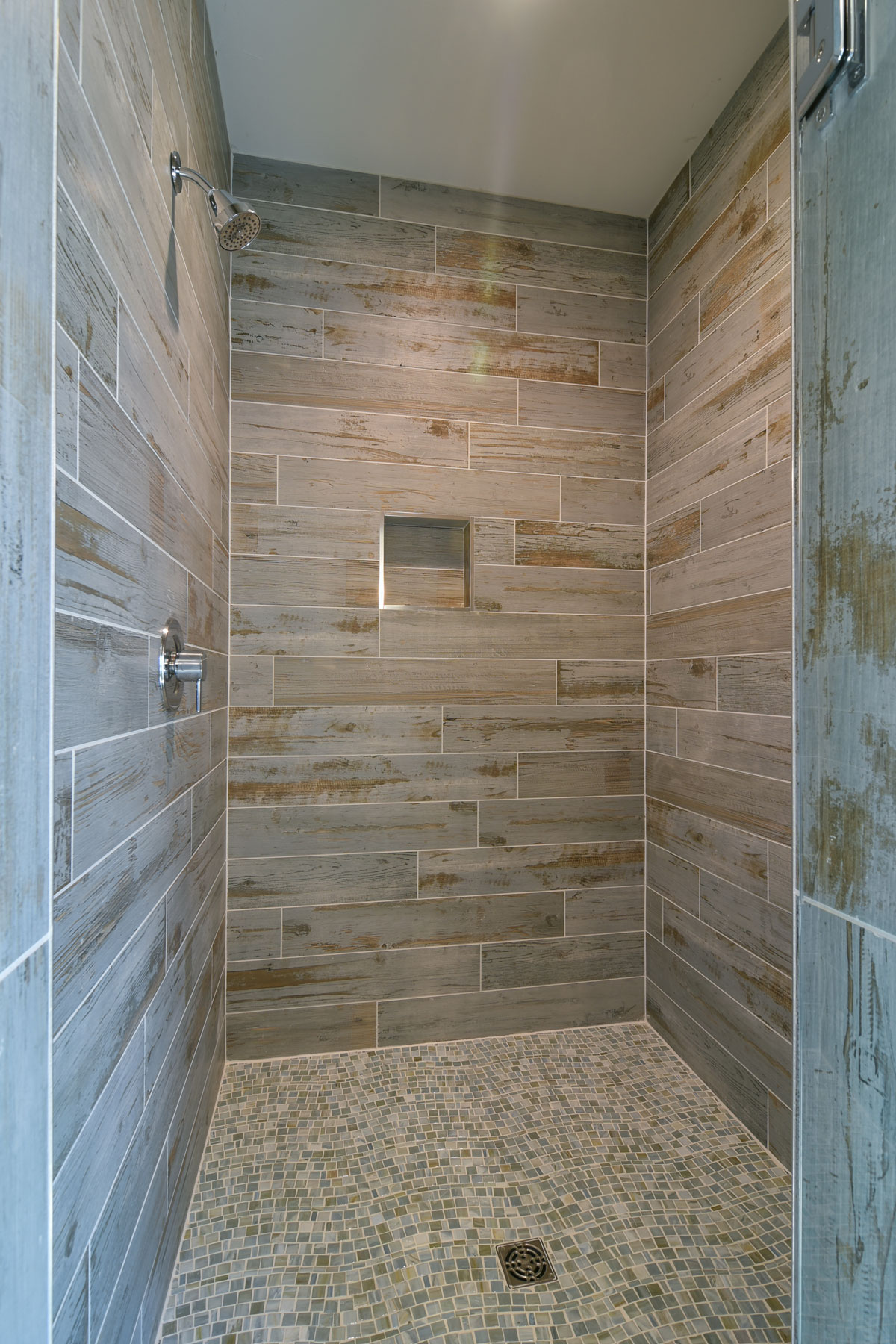 Master shower with wood plank look tiles