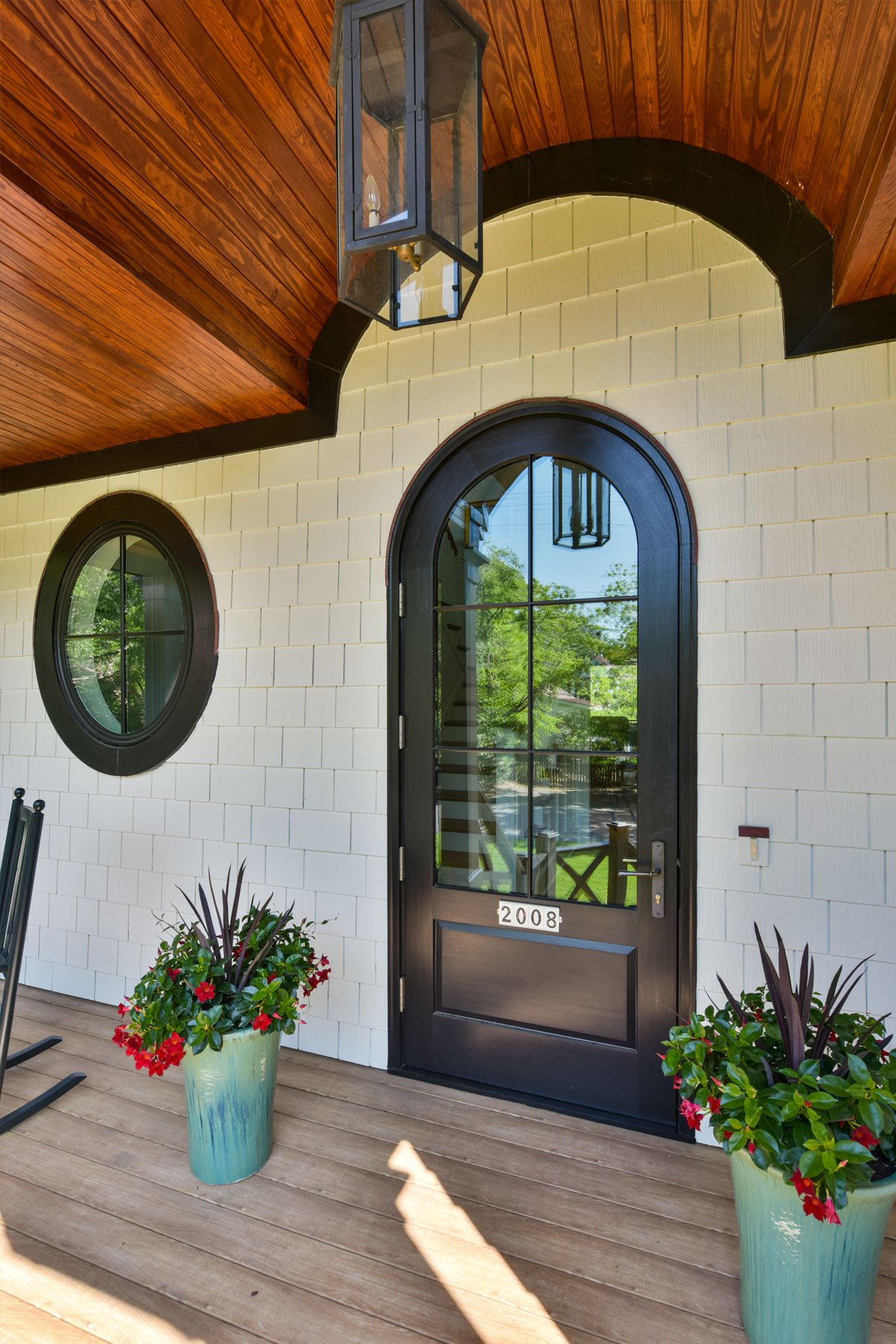 Front door in tudor style coastal home with radius round window