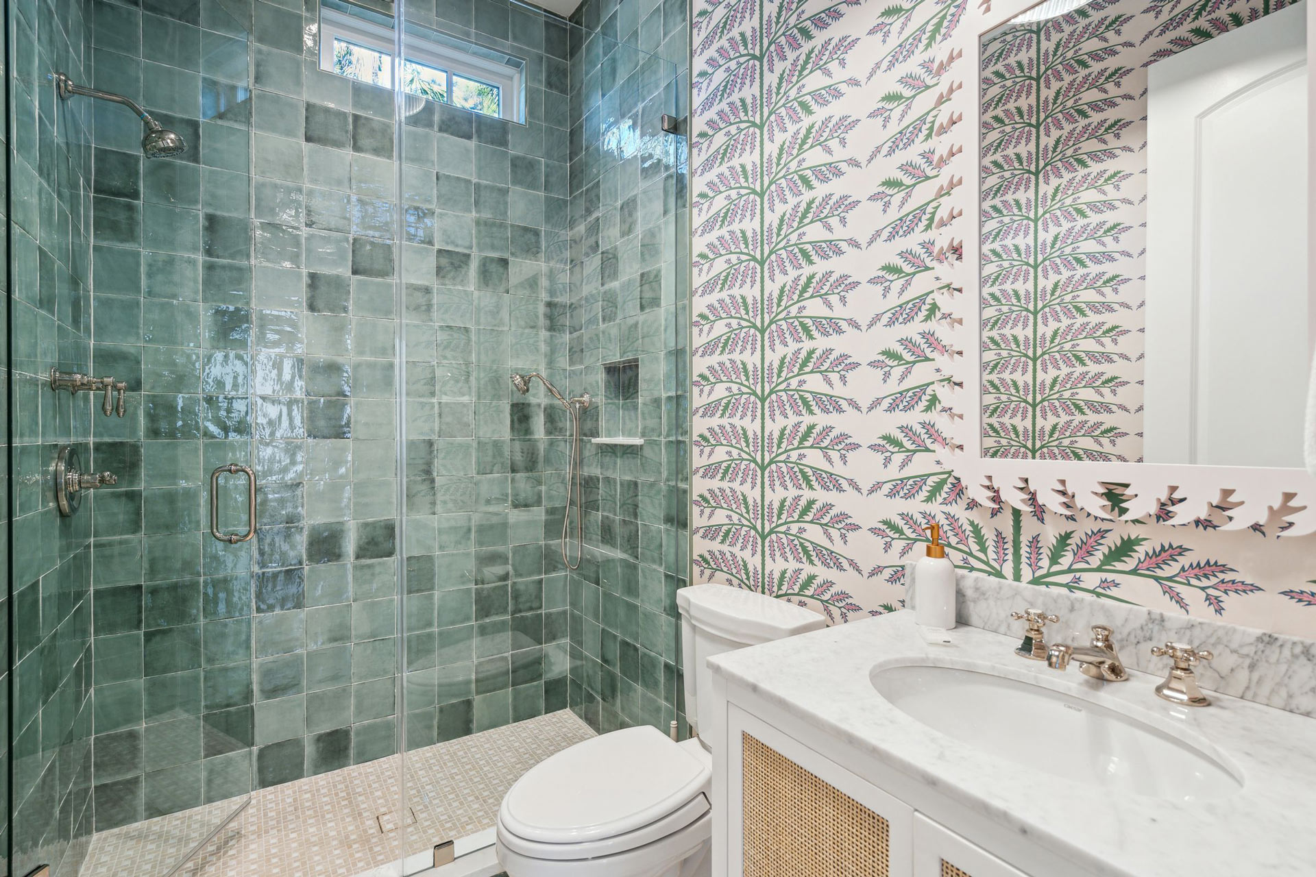 Fun, vibrant guest bath with emerald green tiles and botanical wallpaper