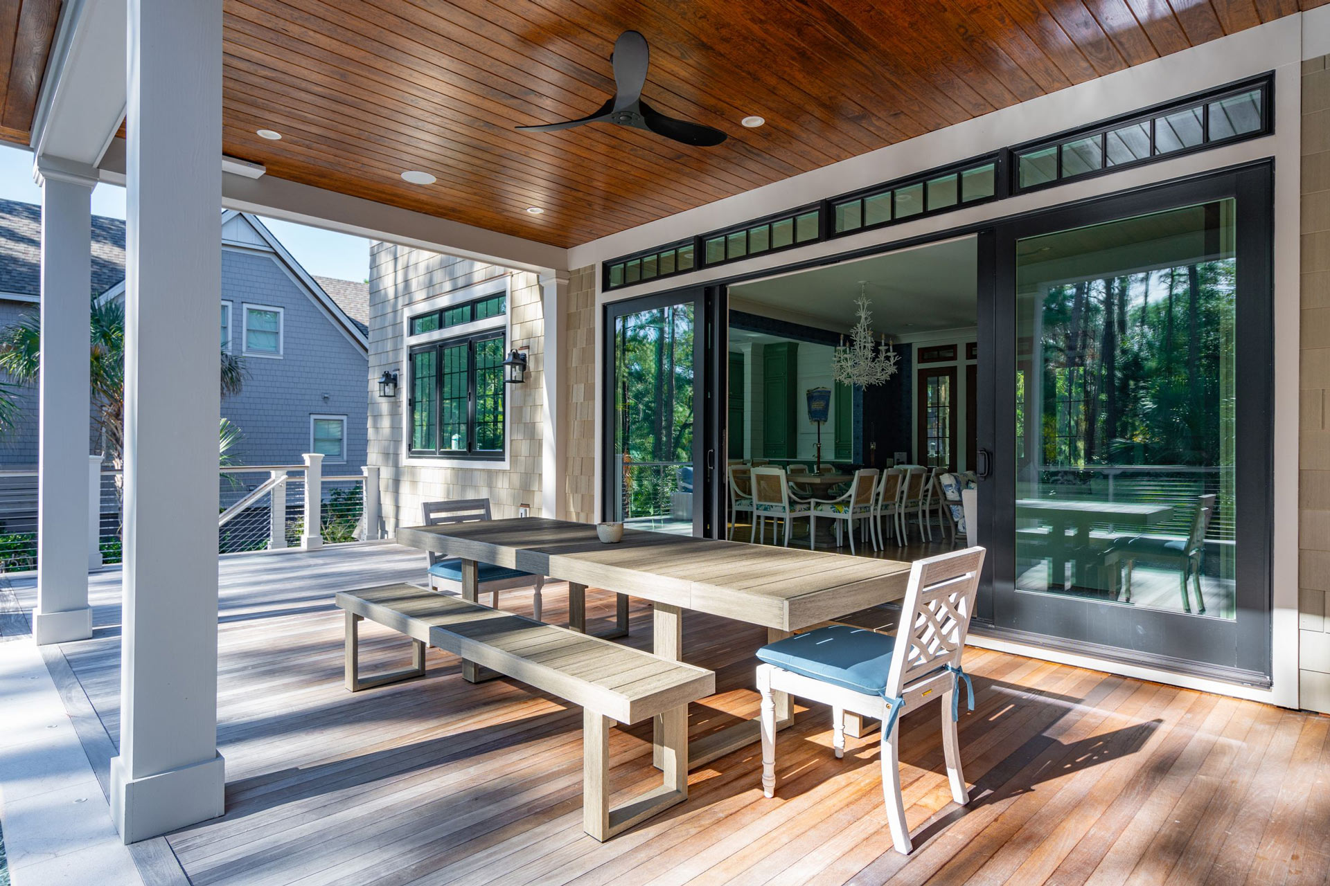 Pocking doors opening to outdoor dining and pool area of coastal Carolina home
