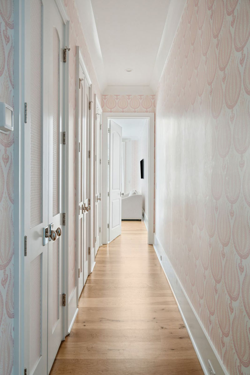 Lovely, elegant soft pink wallpaper lines the hallway